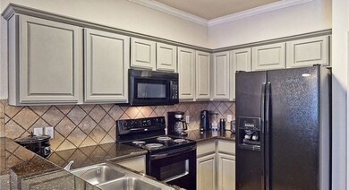 Kitchen with black appliances, a sink, crown moldi