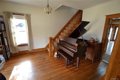 Foyer with pine flooring and ornate woodwork