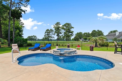 View of pool with a patio area and a pool with connected hot tub