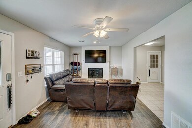 Living room featuring a brick fireplace, ceiling f