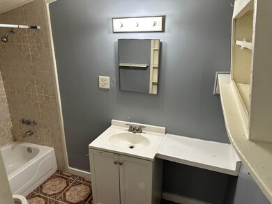 Bathroom with tiled shower / bath and vanity