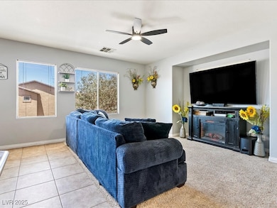 Living area with ceiling fan and baseboards