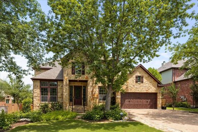 View of front facade with stone siding, driveway,