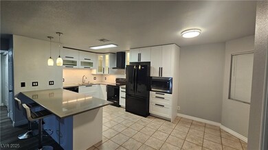 Kitchen with black appliances, a Quartz peninsula,
