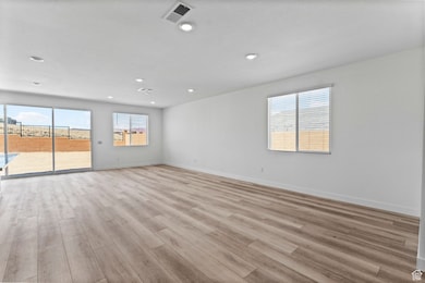 Empty room featuring light wood finished floors and recessed lighting