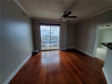 Spare room with hardwood / wood-style flooring, crown molding, and ceiling fan