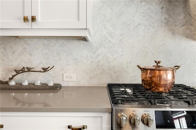 Room details featuring white cabinetry, backsplash