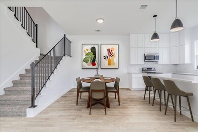 Dining area off kitchen with grand staircase.