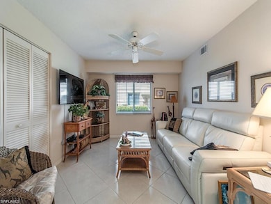 Living room featuring ceiling fan, light tile patterned floors, and baseboards