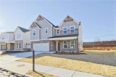 Craftsman house with driveway, stone siding, fence
