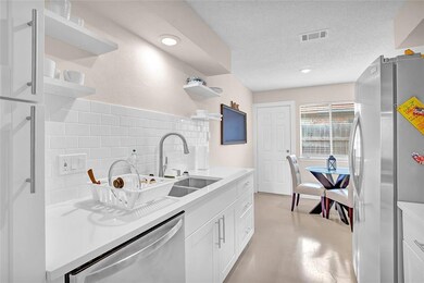 Kitchen featuring visible vents, a sink, open she