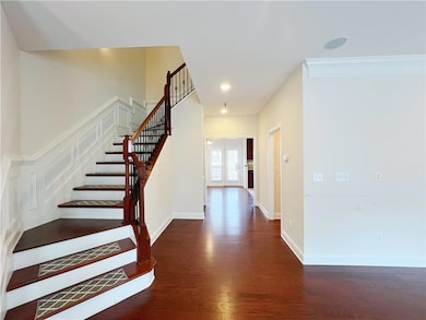 Foyer with baseboards, ornamental molding, wood fi