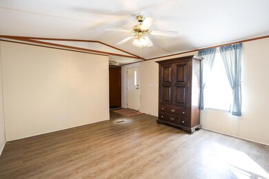 Empty room featuring vaulted ceiling, ceiling fan,