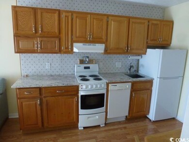 Kitchen with sink, white appliances, decorative ba