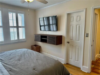 Bedroom with ornamental molding, light wood-style flooring, baseboards, and a ceiling fan