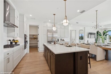 Kitchen with hanging light fixtures, wall chimney 