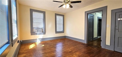 Unfurnished room with hardwood / wood-style flooring, ceiling fan, and baseboards