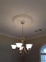 Note the decorative medallion above the chandelier