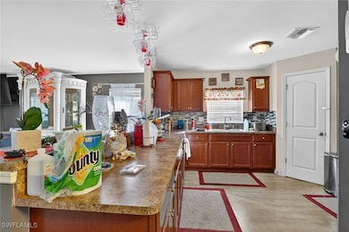 Kitchen with brown cabinetry, backsplash, and light wood-style floors