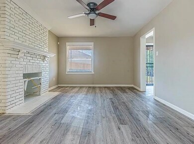 Unfurnished living room featuring wood finished floors, ceiling fan, and a fireplace