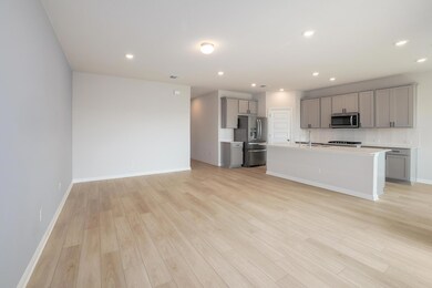 Kitchen with gray cabinetry, light wood finished 