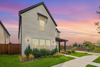 Back of property with brick siding, fence, and a lawn