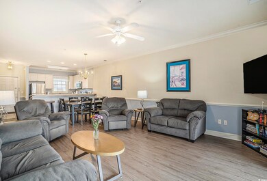 Living room featuring ornamental molding, a chandelier, light wood-type flooring, ceiling fan, and baseboards
