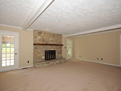 Family Room. A spacious family room with wood burning, stone hearth fireplace and beamed ceiling.
