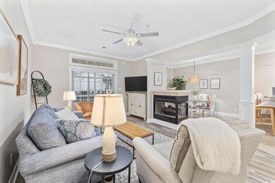 Living room featuring crown molding, light hardwoo