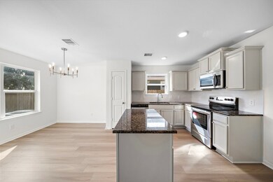 Open, airy kitchen with stunning granite counter tops, tile backsplash, and new stainless appliances.