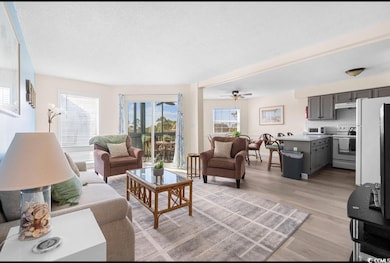 Living area featuring light wood-style floors and a textured ceiling