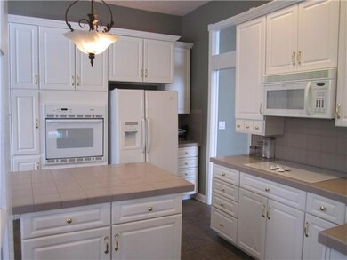 Kitchen. Another view of the kitchen - center island with storage, cook-top range, and built-in oven.