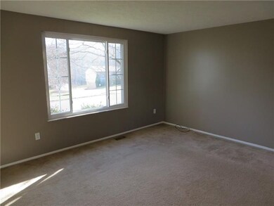The Spacious Living Room Features Neutral Paint & 