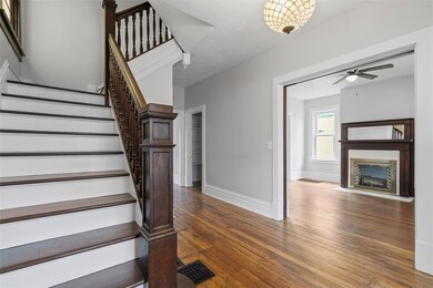 Original hardwood floors and banister greet you