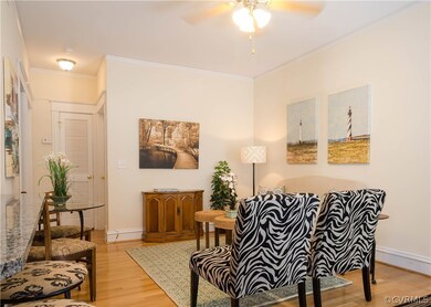 The living room has hardwood floors, crown molding, ceiling fan with light and is open to the kitchen.