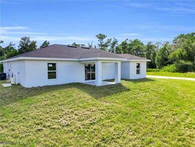 Rear view of property with a lawn, stucco siding, roof with shingles, and a patio