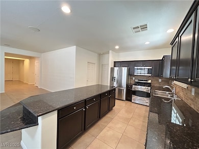 Kitchen featuring visible vents, a sink, appliance