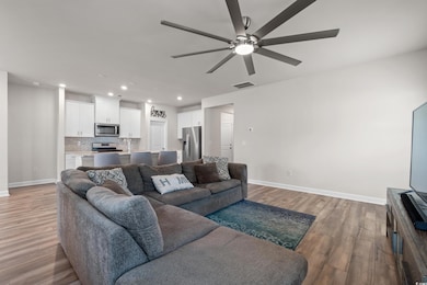 Living area featuring a ceiling fan, baseboards, r