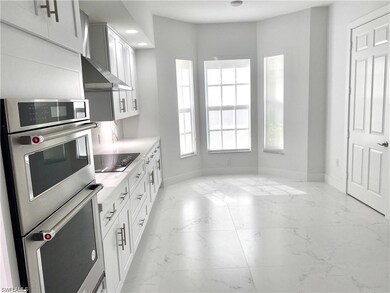 Kitchen with black electric stovetop, stainless st