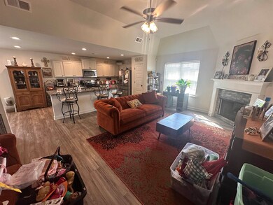 Living room featuring ceiling fan, sink, a firepla