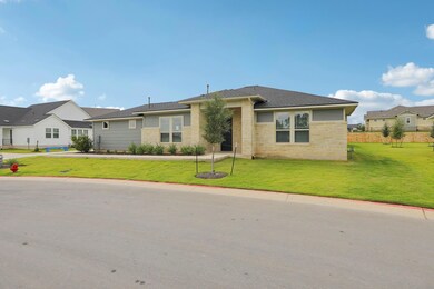 View of front of home featuring a front yard, roof with shingles, a residential view, and stone siding