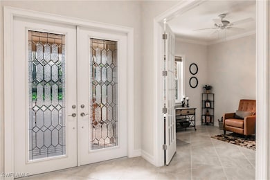 Tiled foyer featuring ceiling fan, french doors wi