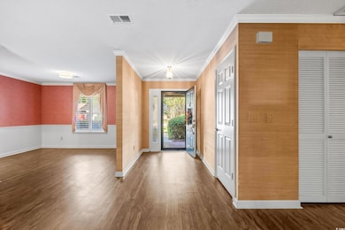 Foyer featuring crown molding and wood finished floors