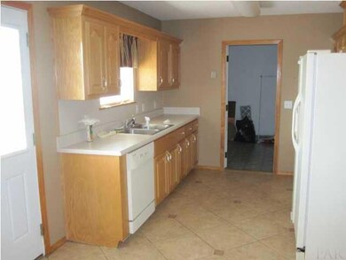 Kitchen from dining room with door to laundry room