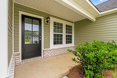 View of exterior entry with a porch and a shingled roof