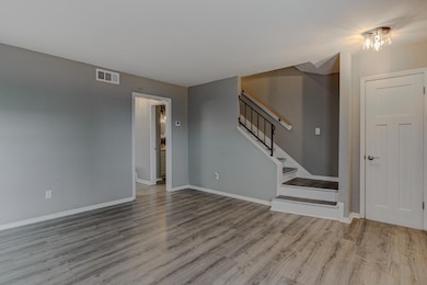 Unfurnished living room with baseboards, stairs, w