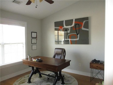Home office with vaulted ceiling, a ceiling fan, w