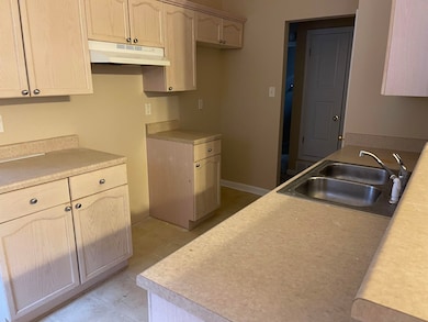 Kitchen with light brown cabinets and sink