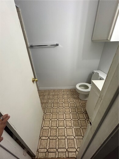 Half bath with light tile patterned flooring and vanity