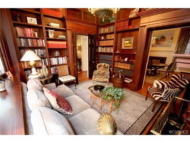A LIBRARY RICH WITH WOOD MOLDINGS AND AN INVITING FIREPLACE TO HELP YOU CATCH UP ON YOUR READING